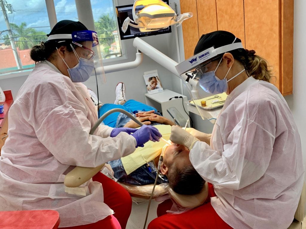Staff wearing PPE & Operating on a patient Flagler Dental Clinic of Miami