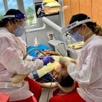 Staff wearing PPE & Operating on a patient Flagler Dental Clinic of Miami